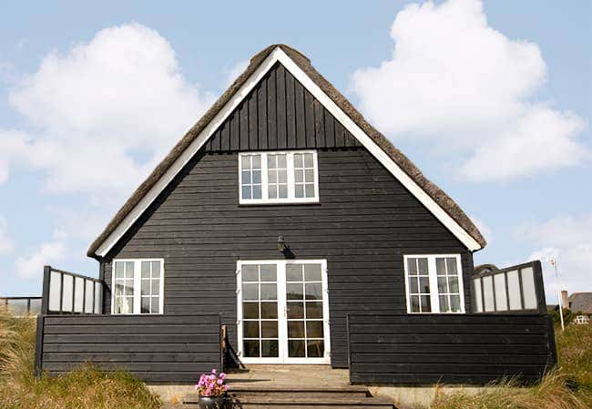 sort sommerhus med vinduer med sprosser